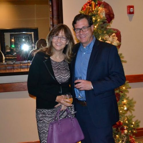 Two people in front of a Christmas tree